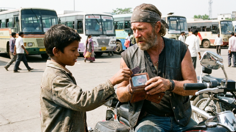 NEXT PART – THE LITTLE BOY RAN ACROSS THE BUS DEPOT TO RETURN A LOST WALLET TO AN OLD BIKER, BUT THE MAN GRABBED IT BACK WITH SUSPICION BEFORE THANKING HIM — AND HIS FACE CHANGED WHEN THE BOY TOUCHED THE SMALL BLACK TICKET HIDDEN BEHIND THE PHOTO SLEEVE